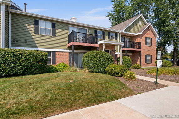 Front view of a two-story residential building with a combination of brick and siding exterior.