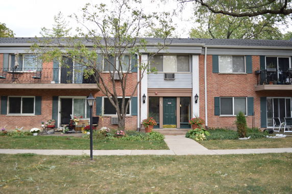 Front view of a two-story brick apartment building with balconies.