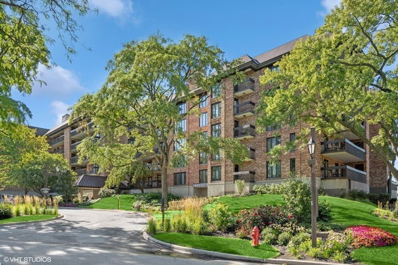 Front view of a multi-story residential building with balconies and brick exterior.