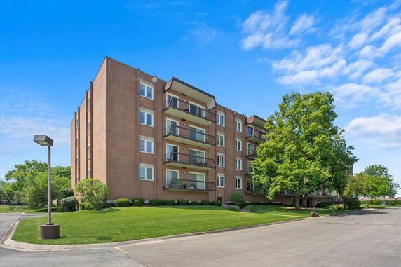 Front view of a multi-story apartment building with balconies.