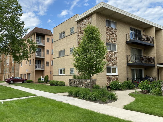 Front view of a multi-story apartment building with balconies.