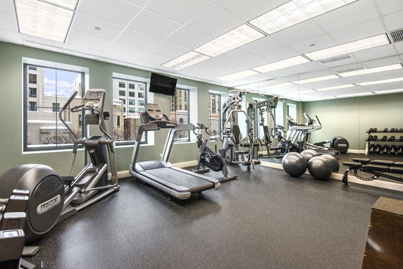 Indoor gym area with exercise equipment including treadmills, stationary bikes, and weights.