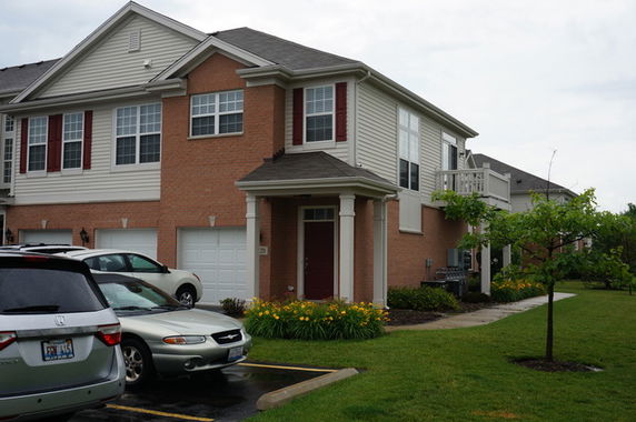 Front view of a two-story house with brick and siding exterior and a double garage.