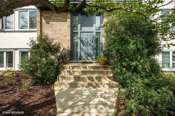 Front view of a house with steps leading to a green door.