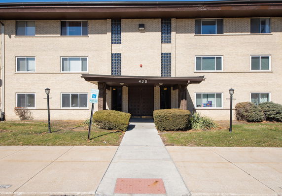 Front view of a three-story building with a covered entrance.