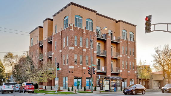 Front view of a multi-story building with brick exterior and large windows.