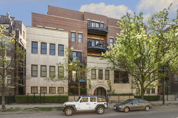 Front view of a multi-story building with balconies and a brick exterior.