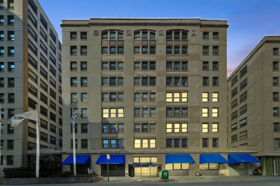 Front view of a multi-story building with blue awnings.