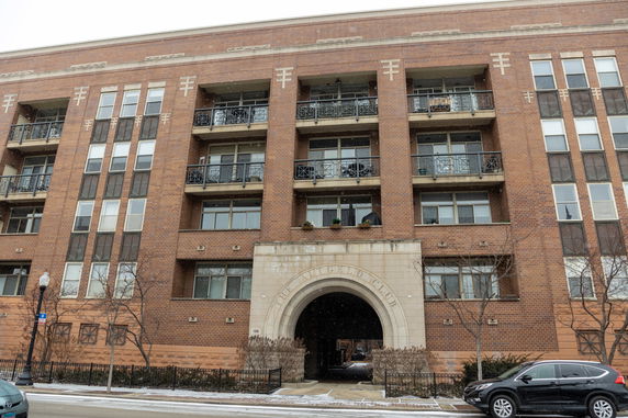 Front view of a multi-story brick building with balconies.