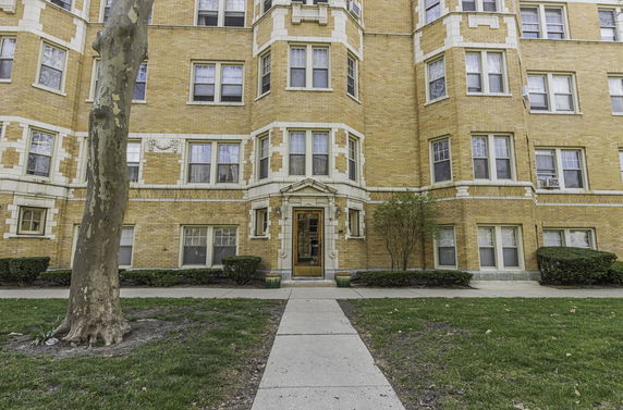Front view of a multi-story brick building with symmetrical windows.