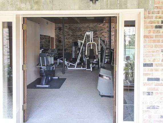 View of a home gym with various exercise equipment including treadmills and weight machines.