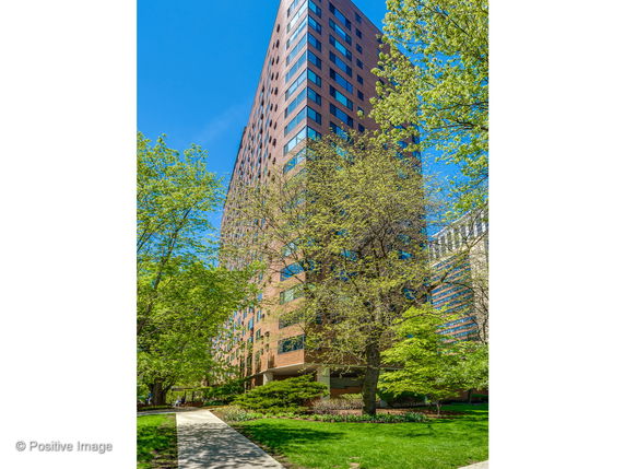 Front view of a high-rise building with a brick facade and numerous windows.