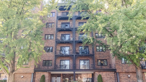 Front view of a multi-story brick building with balconies.