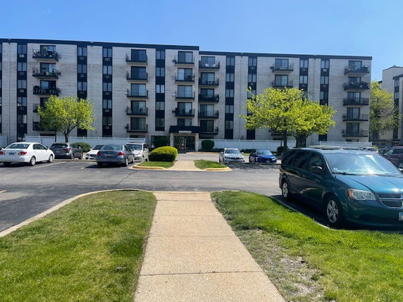 Front view of a multi-story apartment building with multiple balconies.