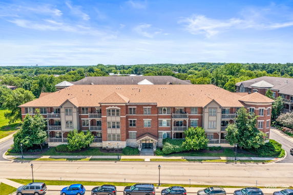 Front view of a three-story brick building with balconies.