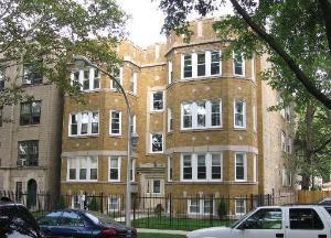 Front view of a multi-story residential building with bay windows.