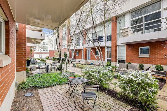 Courtyard view of a residential building with red brick exterior and large windows.