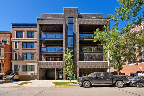 Front view of a modern multi-story apartment building with balconies.