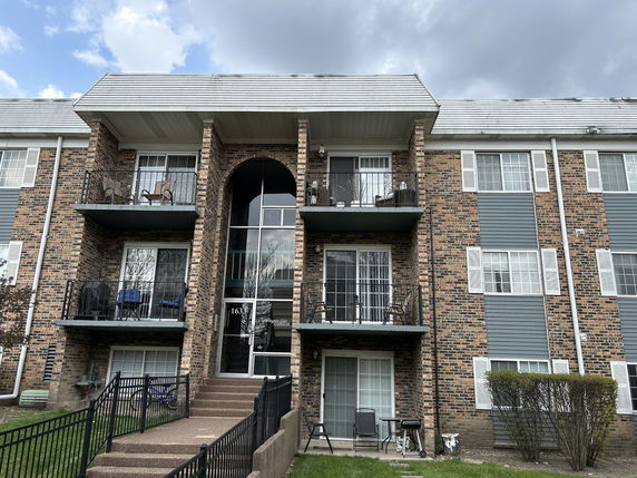 Front view of a multi-story brick building with balconies.