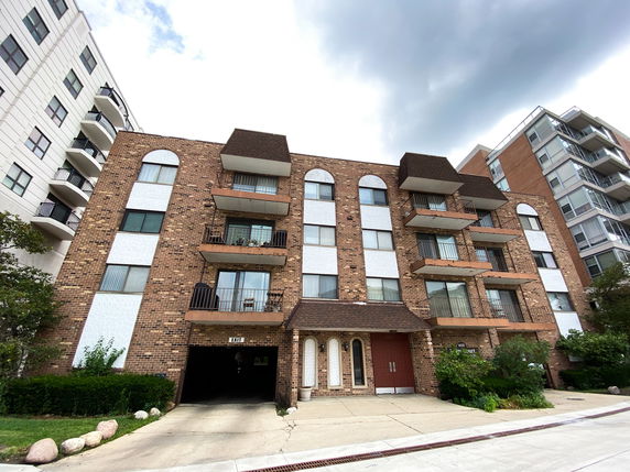 Front view of a multi-story apartment building with balconies.