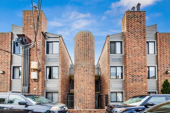 Front view of a brick apartment building with two stairwell towers.