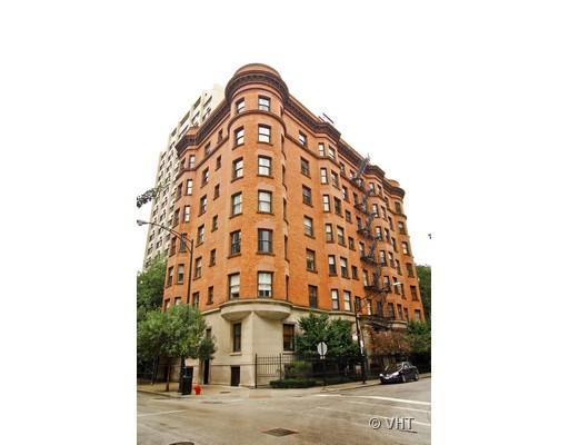 Front view of a multi-story brick apartment building on a street corner.