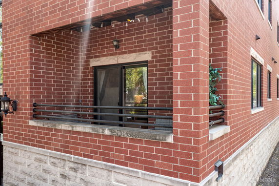 Corner view of a brick exterior building with a small balcony.