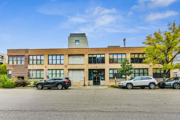 Front view of a two-story building with a flat roof and large windows.
