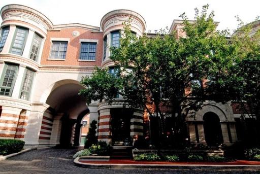 Front view of a multi-story building with an archway and cylindrical sections.
