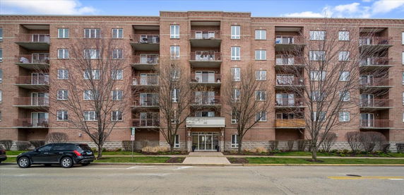 Front view of a multi-story apartment building with balconies.