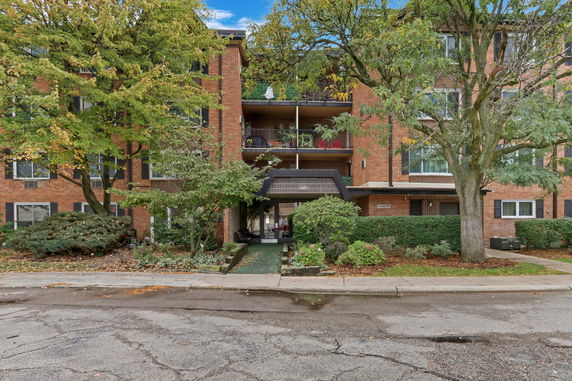 Front view of a multi-story brick apartment building with balconies.