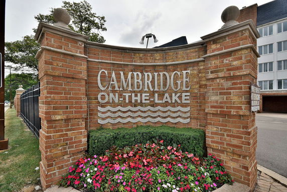 Brick wall with 'Cambridge on the Lake' sign at entrance.