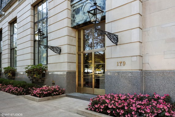 Entrance of a building with tall windows and decorative wall lights.