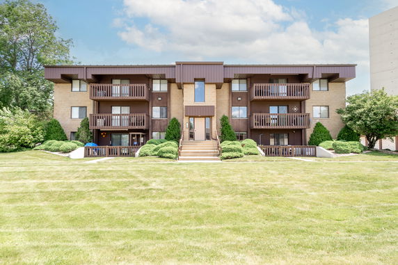 Front view of a three-story apartment building with balconies.