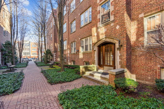 Front view of a brick apartment building with an arched entrance.