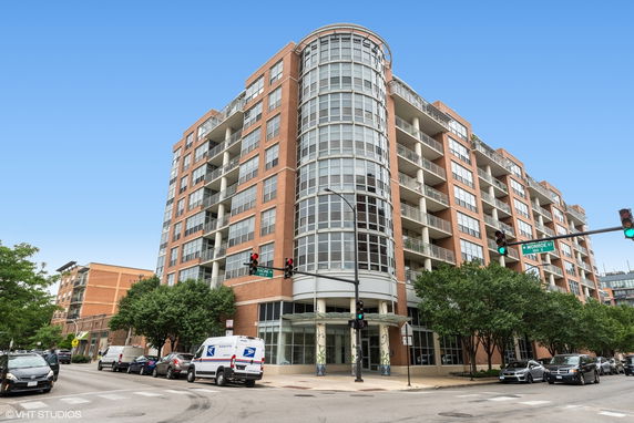 Front view of a multi-story apartment building with large windows and balconies.