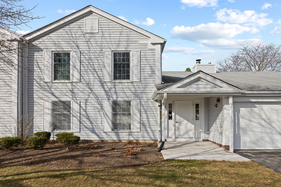 Front view of a two-story house with a garage and an entrance.