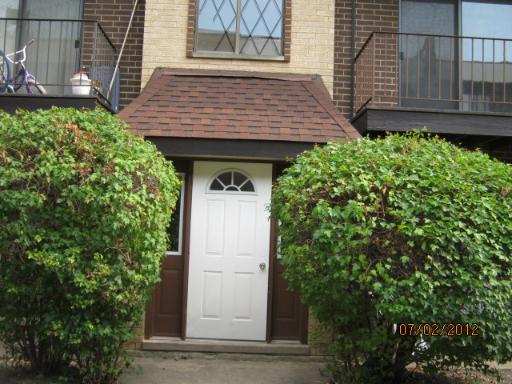 Front view of a residential building with a white door and a small porch.