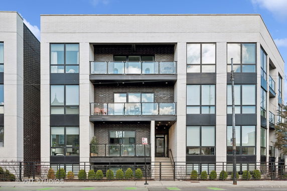 Front view of a modern three-story apartment building with balconies.