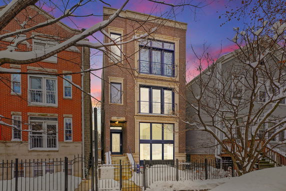 Front view of a multi-story brick building in a snowy setting.