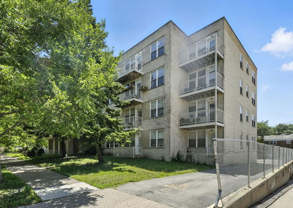Front view of a multi-story apartment building with balconies.
