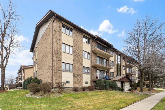 Front view of a multi-story apartment building with balconies.