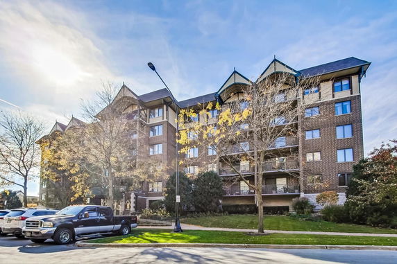 Front view of a multi-story residential building with brick facade and balconies.