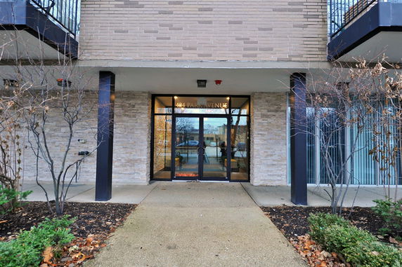 Front view of an entrance to a building with a glass door and brick facade.