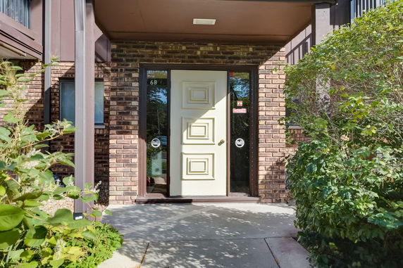 Front view of a house entrance with a decorative door and brick exterior.