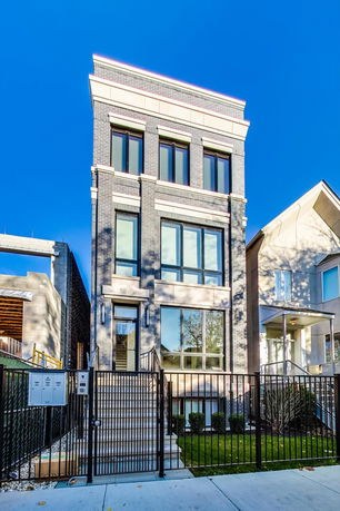 Front view of a three-story modern house with large windows.
