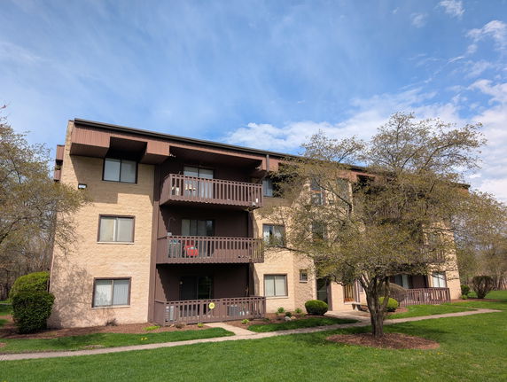 Front view of a three-story apartment building with balconies.