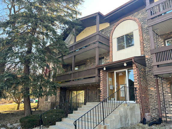 Front view of a multi-story brick building with balconies.