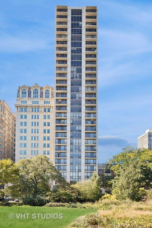 Front view of a tall apartment building with glass balconies.
