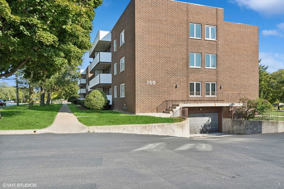 Front view of a brick apartment building with balconies.
